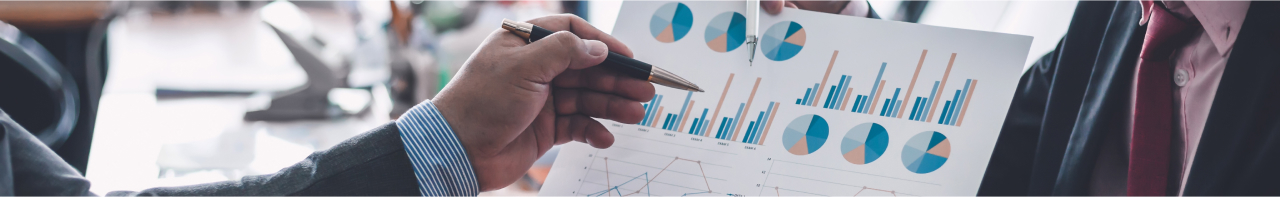 hand holding pencil pointing at graphs and charts